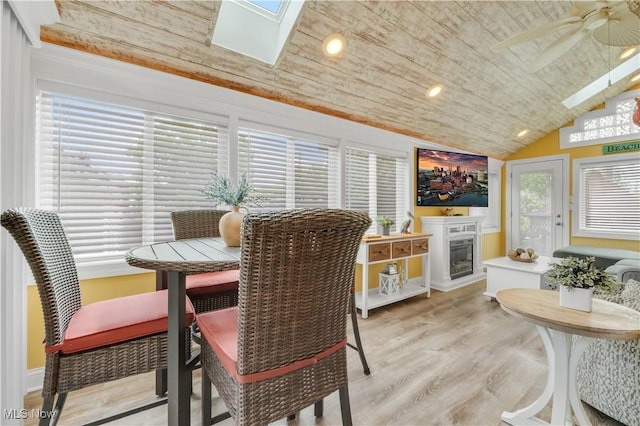 13817 Lakewood Heights Blvd, Lakewood, OH 44107 - dining area featuring wooden ceiling, a skylight, light wood-type flooring, lofted ceiling, and a glass covered fireplace