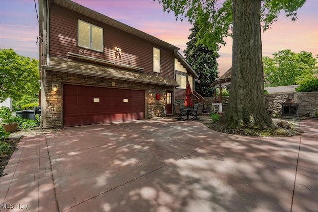 13817 Lakewood Heights Blvd, Lakewood, OH 44107 - view of front of property with an attached garage, stone siding, and driveway