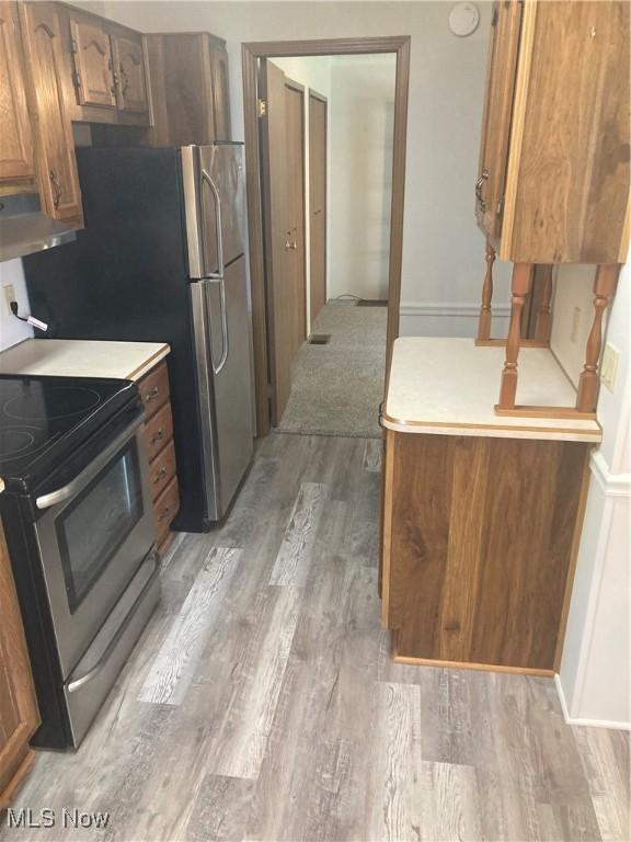 1229 Columbiana Lisbon Rd Unit 39, Columbiana, OH 44408 - kitchen with stainless steel appliances, light wood-style flooring, light countertops, and brown cabinetry