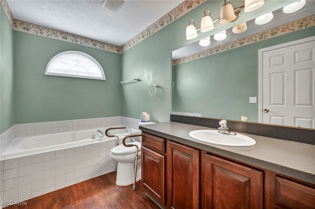 6811 Meadow Ln, Cleveland, OH 44130 - bathroom featuring a bath, wood finished floors, toilet, vanity, and a textured ceiling