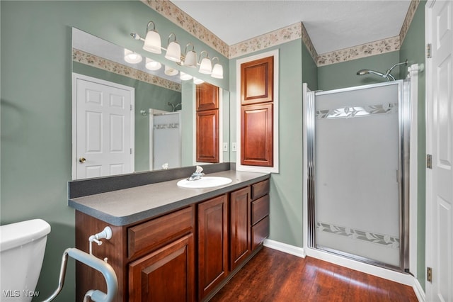 6811 Meadow Ln, Cleveland, OH 44130 - bathroom featuring a shower stall, vanity, wood finished floors, toilet, and baseboards