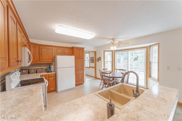 6951 Bunbury Ln, Concord, OH 44077 - kitchen featuring white appliances, a sink, a ceiling fan, light countertops, and brown cabinetry