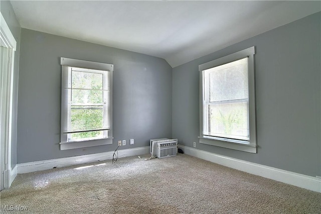 1033 Monnot Pl NW, Canton, OH 44703 - unfurnished room with carpet flooring, vaulted ceiling, baseboards, and a wall mounted air conditioner