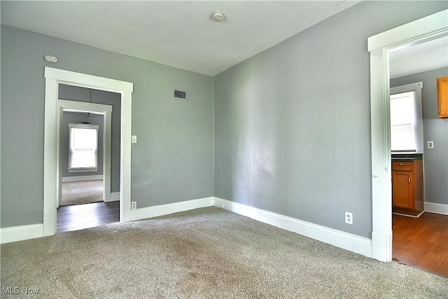 1033 Monnot Pl NW, Canton, OH 44703 - spare room featuring dark colored carpet, baseboards, and a smoke detector