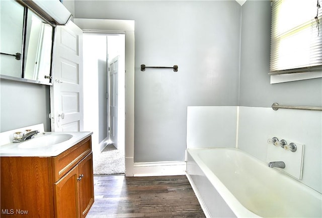 1033 Monnot Pl NW, Canton, OH 44703 - bathroom with a bath, vanity, wood finished floors, and baseboards