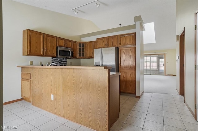 820 Southwestern Run Unit 43, Poland, OH 44514 - kitchen with stainless steel appliances, lofted ceiling, rail lighting, light tile patterned floors, and a peninsula