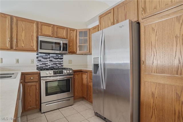820 Southwestern Run Unit 43, Poland, OH 44514 - kitchen featuring appliances with stainless steel finishes, light tile patterned flooring, light countertops, and glass insert cabinets