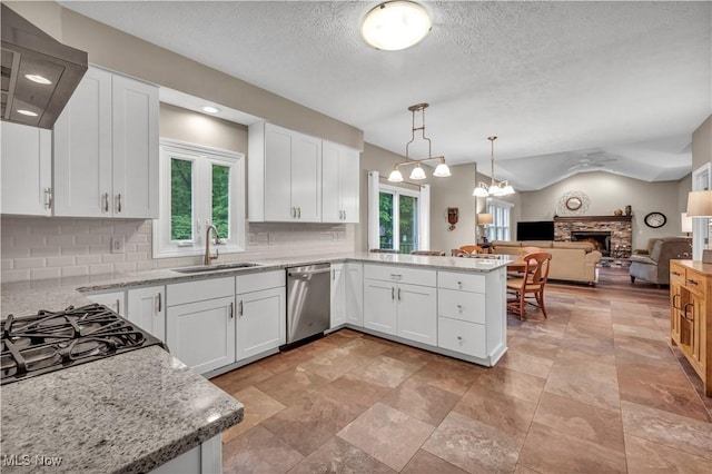 17360 Woodlawn Ct, Strongsville, OH 44149 - kitchen with dishwasher, a sink, a fireplace, a peninsula, and wall chimney exhaust hood