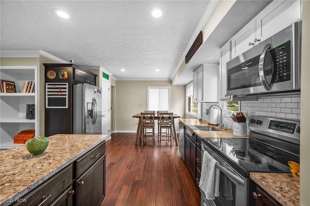 6270 Springwood Rd, Parma Heights, OH 44130 - kitchen with stainless steel appliances, a sink, ornamental molding, light stone countertops, and backsplash