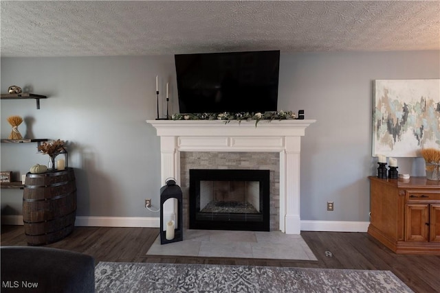 10957 Mogadore Ave NW, Uniontown, OH 44685 - detailed view of wood finished floors, a tiled fireplace, baseboards, and a textured ceiling