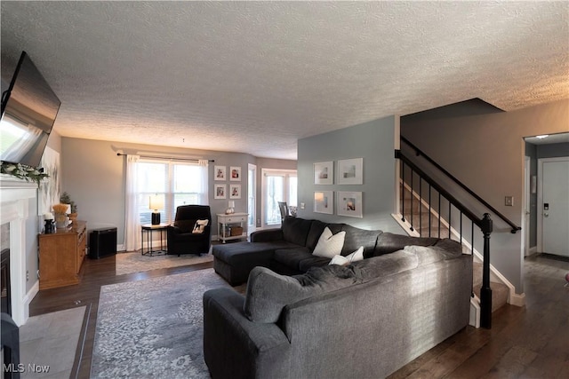 10957 Mogadore Ave NW, Uniontown, OH 44685 - living room featuring wood finished floors, a textured ceiling, stairway, and a fireplace