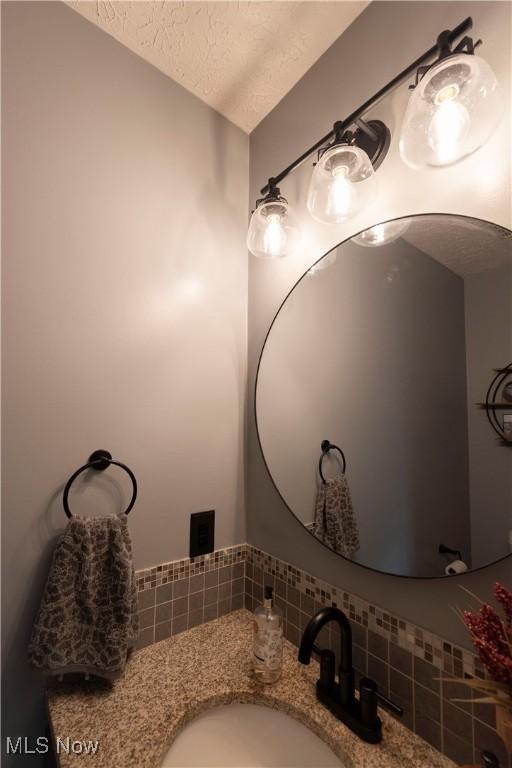 10957 Mogadore Ave NW, Uniontown, OH 44685 - bathroom with a textured ceiling and vanity