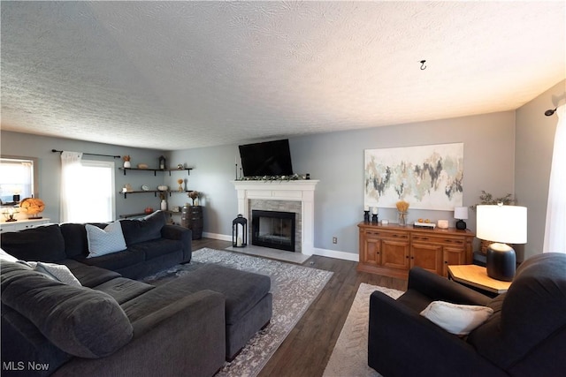 10957 Mogadore Ave NW, Uniontown, OH 44685 - living room featuring a fireplace with flush hearth, a textured ceiling, dark wood-style flooring, and baseboards