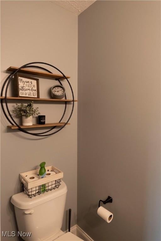 10957 Mogadore Ave NW, Uniontown, OH 44685 - half bathroom with toilet, a textured ceiling, and baseboards