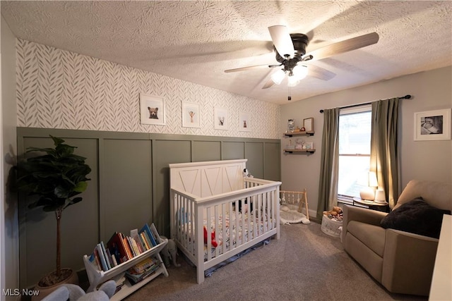 10957 Mogadore Ave NW, Uniontown, OH 44685 - bedroom featuring wallpapered walls, a textured ceiling, a crib, carpet, and a decorative wall
