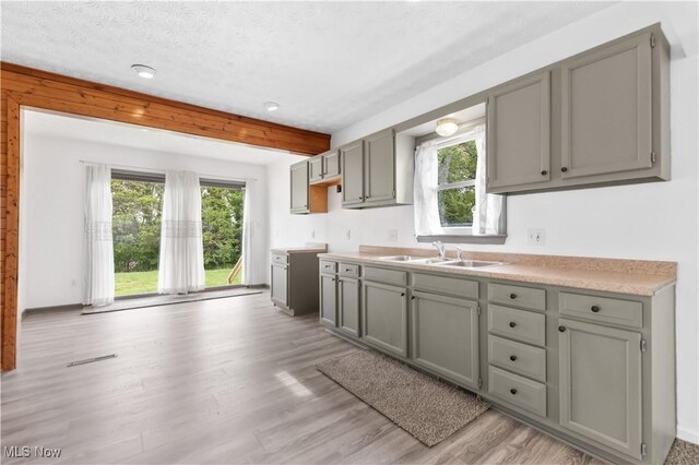 703 Annapolis Ave, Akron, OH 44310 - kitchen featuring gray cabinets, a sink, beamed ceiling, and a textured ceiling