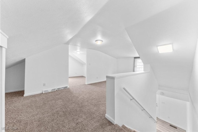 703 Annapolis Ave, Akron, OH 44310 - additional living space with carpet floors, vaulted ceiling, baseboards, and a textured ceiling