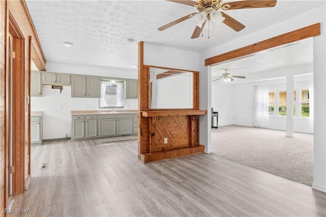 703 Annapolis Ave, Akron, OH 44310 - unfurnished living room with ceiling fan, a sink, light wood-style floors, and baseboards