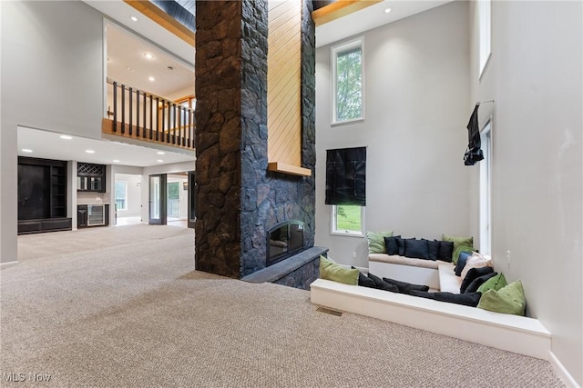 1820 Schneider St NW, North Canton, OH 44720 - living room with a high ceiling, carpet floors, a stone fireplace, recessed lighting, and plenty of natural light