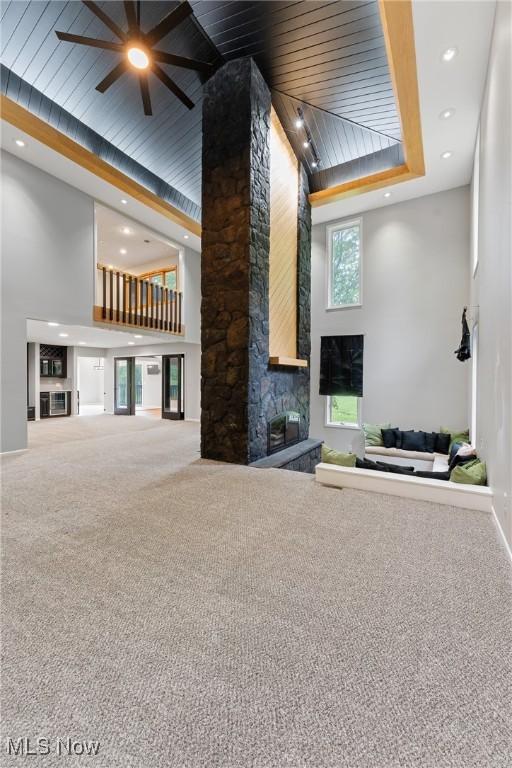 1820 Schneider St NW, North Canton, OH 44720 - unfurnished living room with carpet, a fireplace, ceiling fan, a high ceiling, and recessed lighting