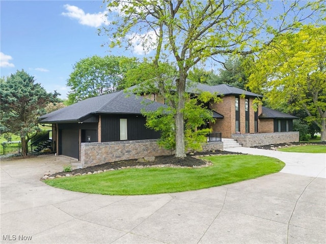 1820 Schneider St NW, North Canton, OH 44720 - view of front of property with driveway, a front yard, stone siding, roof with shingles, and a garage