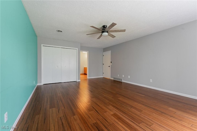1820 Schneider St NW, North Canton, OH 44720 - unfurnished bedroom with baseboards, wood finished floors, a closet, a ceiling fan, and a textured ceiling