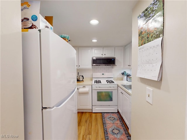 1651 Mentor Ave Unit 3002, Painesville, OH 44077 - kitchen featuring white appliances, white cabinetry, light countertops, light wood-style floors, and recessed lighting