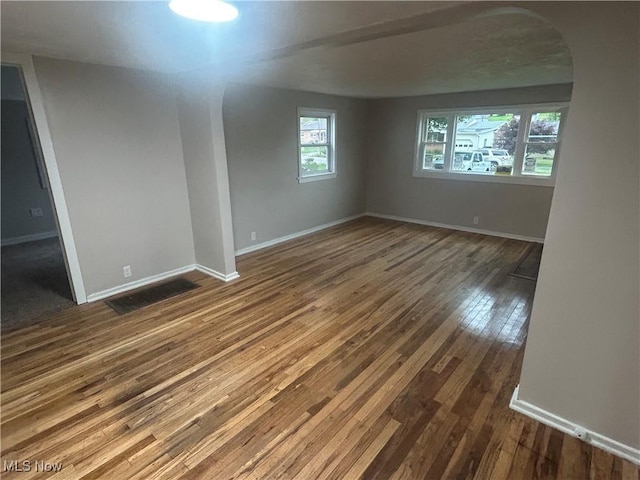 1706 Adams St, Coshocton, OH 43812 - unfurnished room featuring arched walkways, hardwood / wood-style floors, and baseboards