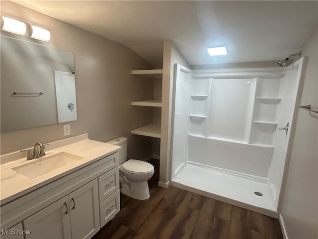 1706 Adams St, Coshocton, OH 43812 - bathroom with a walk in shower, wood finished floors, vanity, toilet, and vaulted ceiling