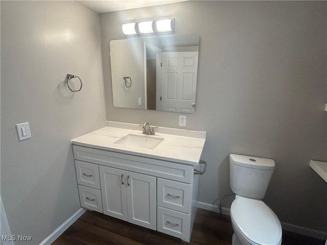 1706 Adams St, Coshocton, OH 43812 - bathroom featuring vanity, baseboards, toilet, and wood finished floors