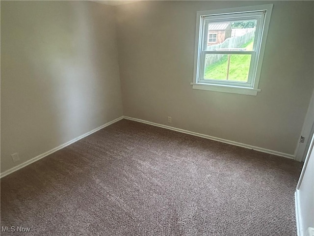 1706 Adams St, Coshocton, OH 43812 - empty room with dark colored carpet and baseboards