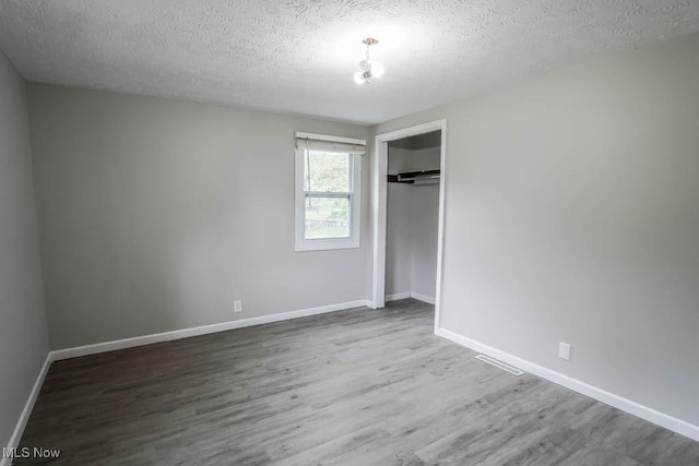 29655 Buck Rd, Salem, OH 44460 - unfurnished bedroom with a textured ceiling, wood finished floors, a closet, and baseboards