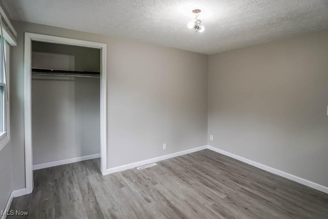 29655 Buck Rd, Salem, OH 44460 - unfurnished bedroom with wood finished floors, a textured ceiling, a closet, and baseboards