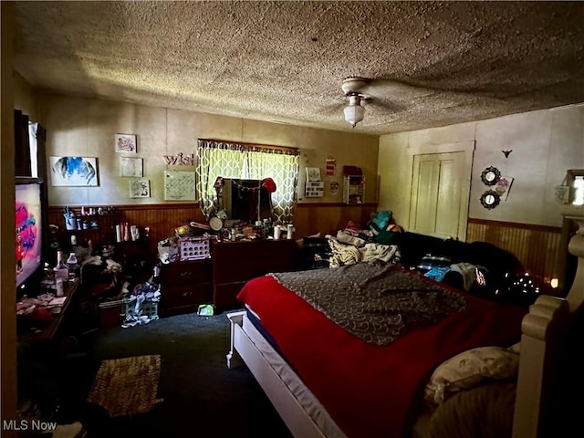 1836 Colerain Pike, Martins Ferry, OH 43935 - bedroom featuring a wainscoted wall, carpet floors, a textured ceiling, wood walls, and a ceiling fan