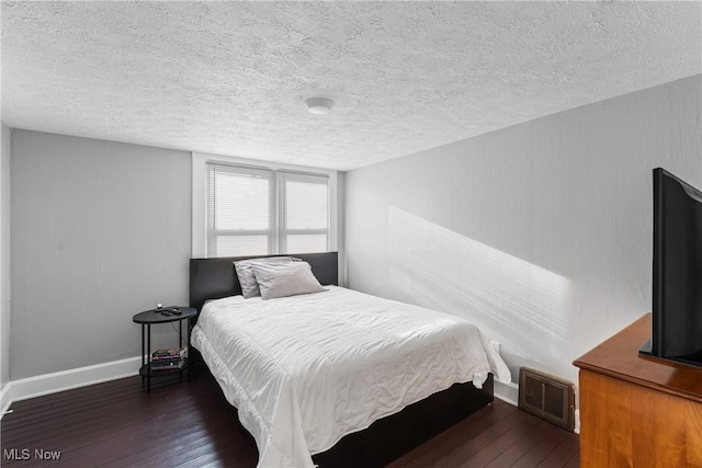 360 Woodside Ave NE, North Canton, OH 44720 - bedroom featuring dark wood finished floors, a textured ceiling, and baseboards