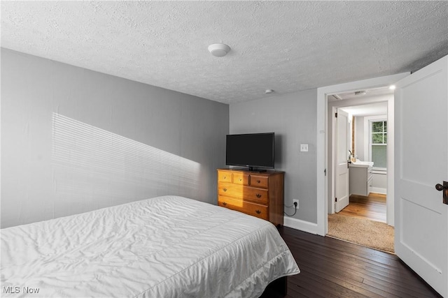 360 Woodside Ave NE, North Canton, OH 44720 - bedroom with dark wood-type flooring, a textured ceiling, and baseboards