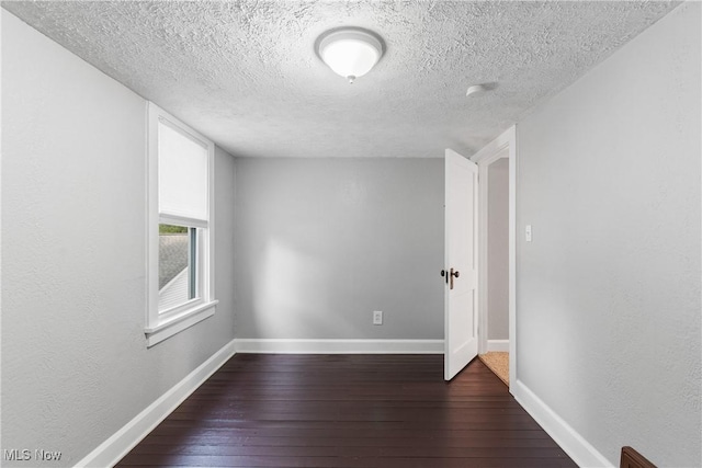 360 Woodside Ave NE, North Canton, OH 44720 - empty room with dark wood finished floors, a textured ceiling, and baseboards