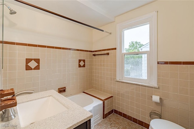 4092 Charlton Rd, South Euclid, OH 44121 - full bathroom with tile walls, vanity, toilet, shower / tub combination, and a wainscoted wall
