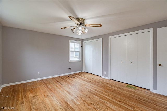 4092 Charlton Rd, South Euclid, OH 44121 - unfurnished bedroom featuring two closets, baseboards, light wood-style flooring, and ceiling fan