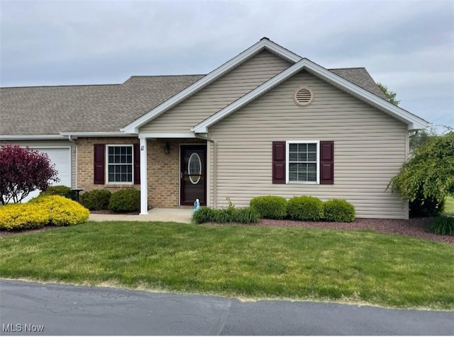 170 Sandy Ct Unit 11, New Middletown, OH 44442 - view of front of house featuring a garage, a front yard, roof with shingles, and brick siding