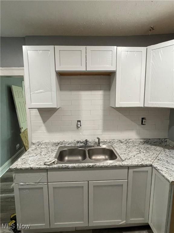 14413 Coit Rd, Cleveland, OH 44110 - kitchen with a sink, tasteful backsplash, and white cabinetry