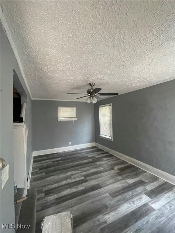 14413 Coit Rd, Cleveland, OH 44110 - spare room featuring a textured ceiling, a ceiling fan, wood finished floors, and baseboards