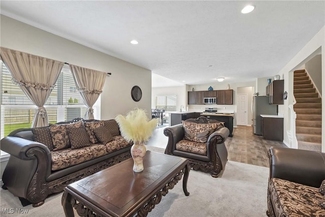 4527 Cupola Dr, Lorain, OH 44053 - living room with stairway, light carpet, and recessed lighting