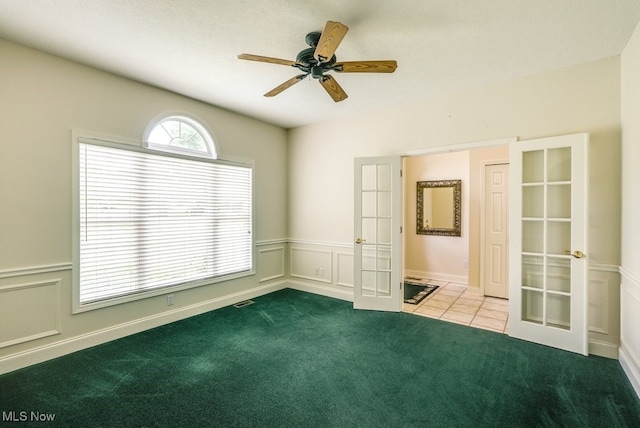 835 Thelma Dr, Wadsworth, OH 44281 - empty room with french doors, carpet, a wainscoted wall, a decorative wall, and ceiling fan