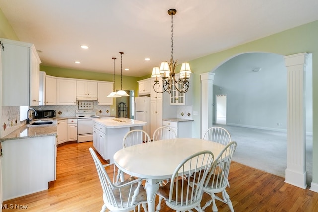 835 Thelma Dr, Wadsworth, OH 44281 - dining area with decorative columns, arched walkways, light wood-type flooring, recessed lighting, and baseboards