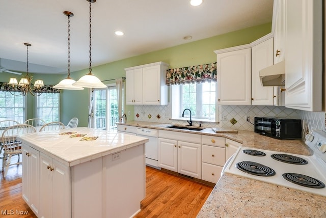 835 Thelma Dr, Wadsworth, OH 44281 - kitchen with a sink, under cabinet range hood, white appliances, a chandelier, and a center island