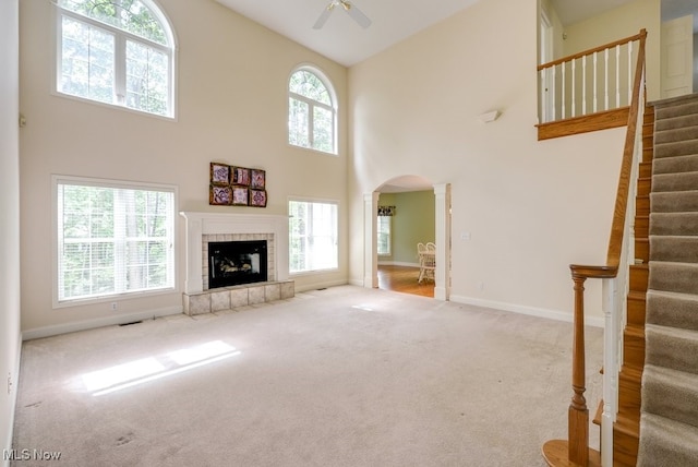 835 Thelma Dr, Wadsworth, OH 44281 - unfurnished living room with arched walkways, ceiling fan, high vaulted ceiling, carpet, and stairway
