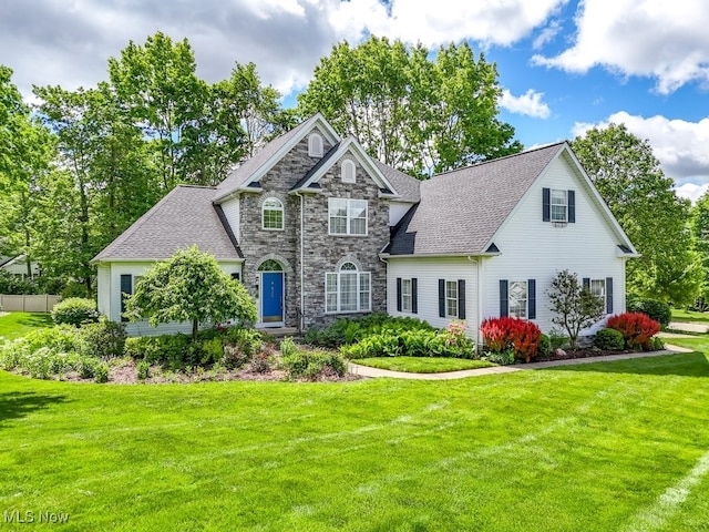 835 Thelma Dr, Wadsworth, OH 44281 - view of front of house with a front yard, stone siding, and a shingled roof