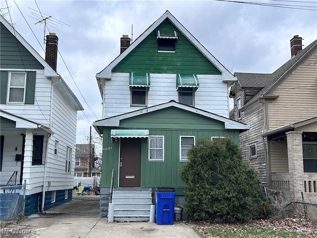 2920 E 111th St, Cleveland, OH 44104 - view of front facade featuring board and batten siding, entry steps, and a chimney