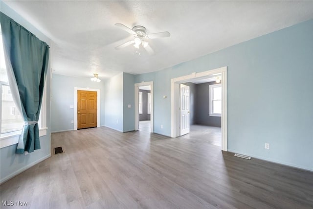 3399 E 65th St, Cleveland, OH 44127 - unfurnished living room featuring a ceiling fan, wood finished floors, and baseboards